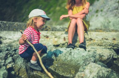 Genç bir anne ve bebeği yazın deniz kenarındaki kayalarda dinleniyorlar.