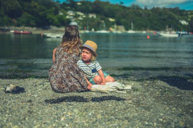 Genç bir anne ve bebeği bir yaz günü nehir kenarında oturuyorlar.