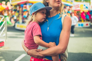 Genç bir anne karnında bebeğini lunaparkta taşıyor.