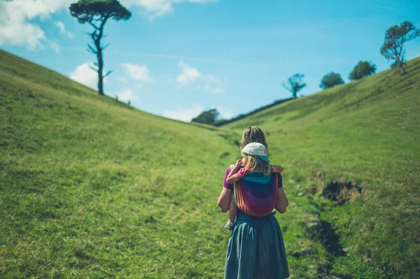 Young Mother Walking Field Her Toddler Sling Her Back — Stock Photo, Image