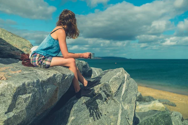 Genç Bir Kadın Deniz Kenarındaki Kayalarda Oturuyor Bir Fincan Çay — Stok fotoğraf