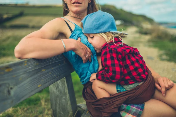 Una Joven Madre Está Amamantando Niño Grande Banco Junto Mar — Foto de Stock