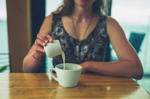 Young Woman Pouring Cream Her Coffee Cafe — Stock Photo, Image