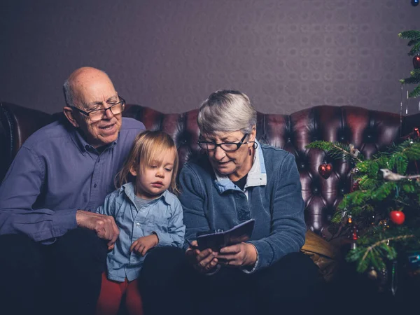 Piccolo Bambino Suoi Nonni Sono Seduti Divano Guardare Uno Smartphone — Foto Stock