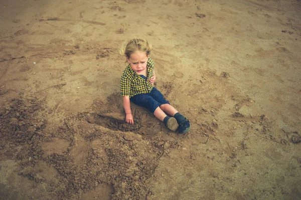 Ένα Μικρό Παιδί Κάθεται Στην Άμμο Μια Παραλία — Φωτογραφία Αρχείου