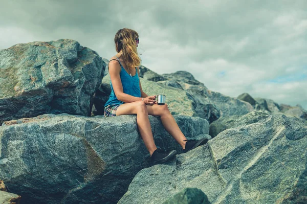 Uma Jovem Mulher Está Sentada Algumas Rochas Junto Mar Está — Fotografia de Stock