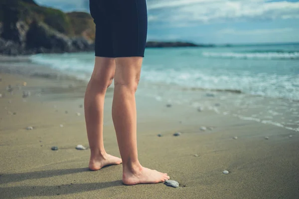 一位穿着湿衣的年轻女子在海滩上的腿和脚 — 图库照片