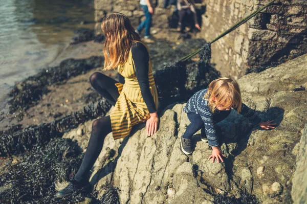 妈妈和小孩在河边的岩石上放松 — 图库照片