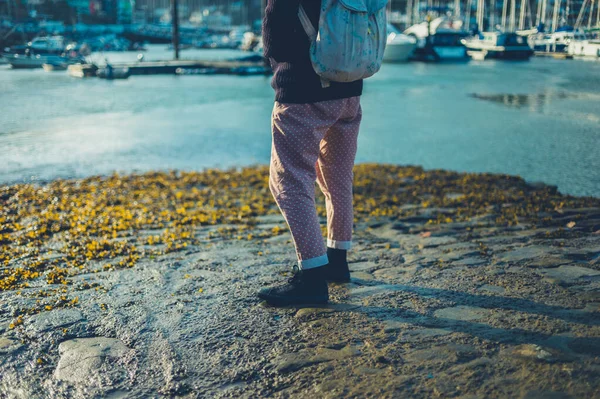 Young woman standing by the water in harbor — Stock Photo, Image