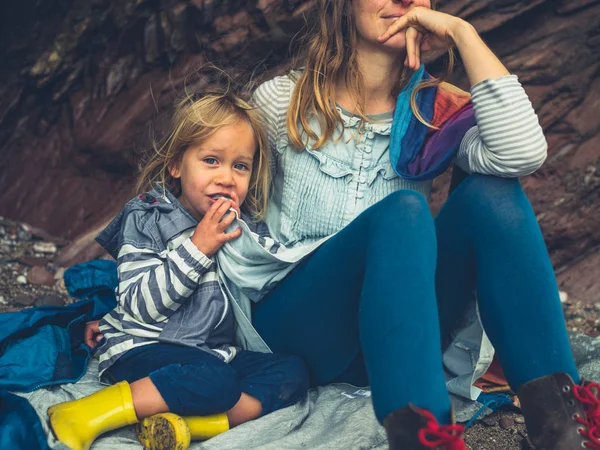 Joven madre y niño sentado en la playa — Foto de Stock