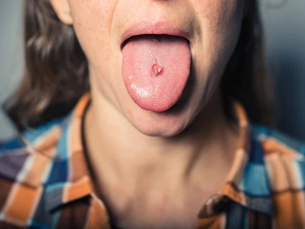 Nahaufnahme auf der durchbohrten Zunge einer Frau — Stockfoto