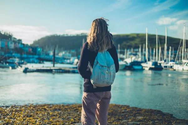 Ung kvinna står vid vattnet i hamnen — Stockfoto