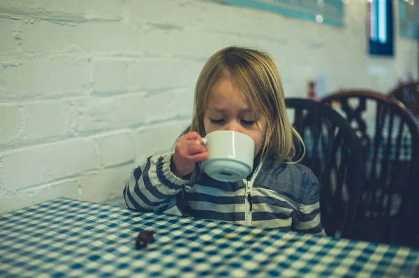 Маленький малюк п'є чай в кафе — стокове фото
