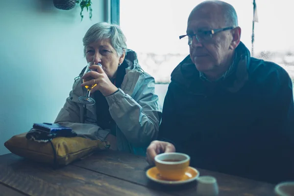 Pár v důchodu pije kávu a mošt v kavárně — Stock fotografie