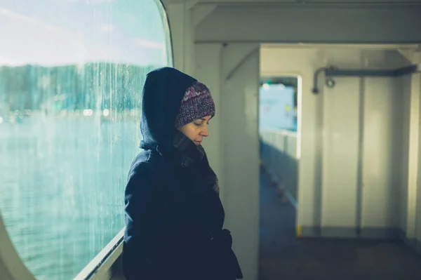 Mujer joven apoyada contra ventana en ferry —  Fotos de Stock