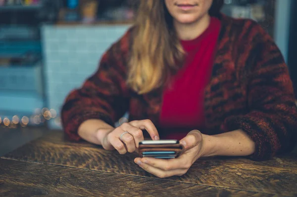 Ung Kvinna Använder Smartphone Vid Ett Bord Ett Kafé — Stockfoto