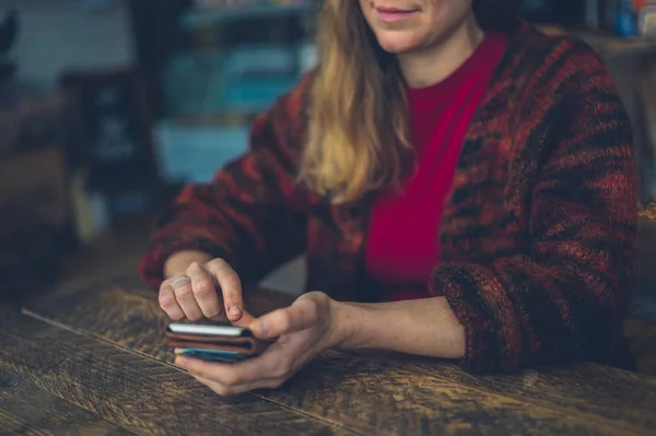 Una Joven Está Usando Teléfono Inteligente Una Mesa Café — Foto de Stock