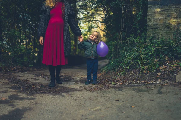 Μια Έγκυος Γυναίκα Μωρό Της Κρατώντας Ένα Μπαλόνι Περπατά Στο — Φωτογραφία Αρχείου