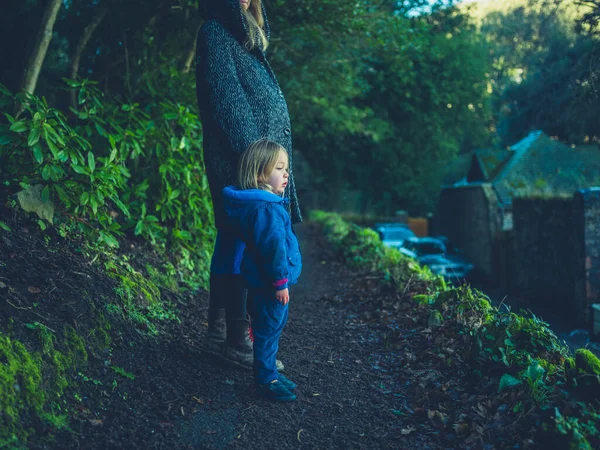 Young mother and toddler standing on nature path in winter — Stockfoto