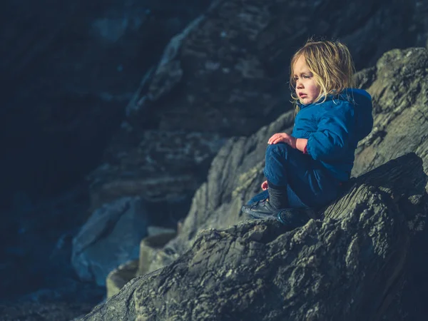 Toddler relaxing on rock in winter — Stok fotoğraf