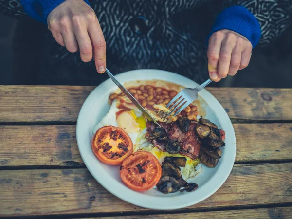 Junge Frau isst englisches Frühstück im Café — Stockfoto