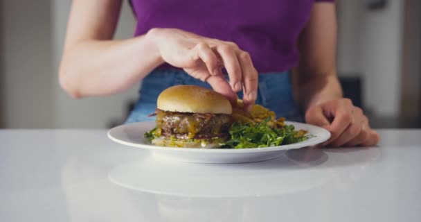 Jovem Está Pegando Algumas Batatas Fritas Prato Com Hambúrguer — Vídeo de Stock