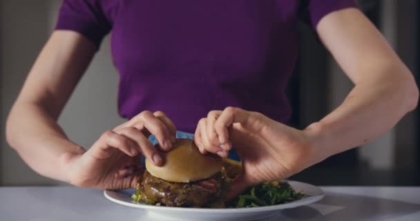 Eine Junge Frau Isst Abends Einen Hamburger — Stockvideo