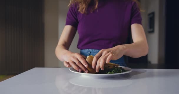 若い女性がハンバーガーを食べている — ストック動画