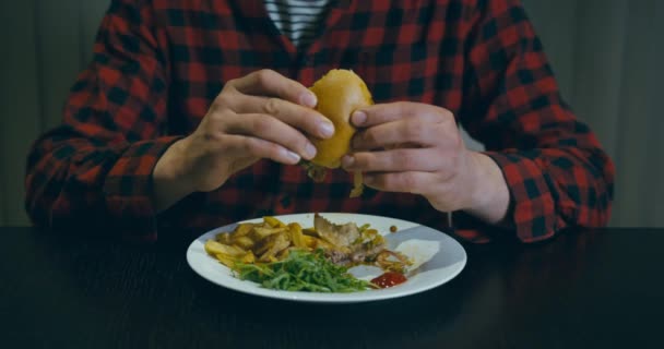 Egy Hipszter Inget Viselő Fiatalember Hamburgert Eszik Dicsőséges 100Fps Lassított — Stock videók