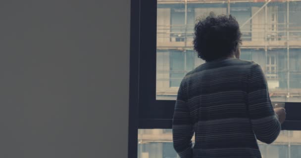 Young man drinking coffe by window — Stock video