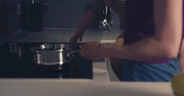 Mother and baby turning on cooker — Stock video