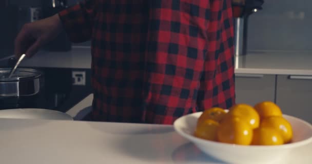 Young man poaching eggs at home — Stock video