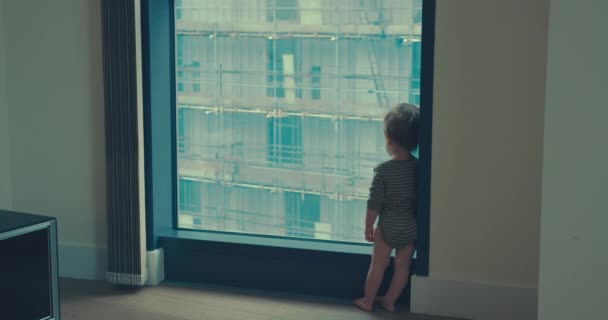 Little boy stading by window then his mother joins him — Stock Video