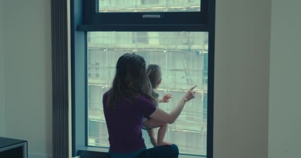 Mor med barn vid fönstret — Stockvideo