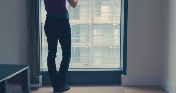 Tilting shot de mujer con café por ventana en la ciudad — Vídeos de Stock