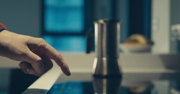 Jeune homme allumant plaque à induction pour faire du café 