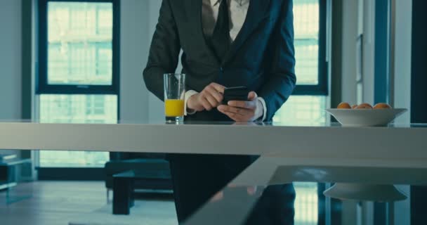Бизнесмен использует смартфон и пьет сок в замедленной съемке — стоковое видео