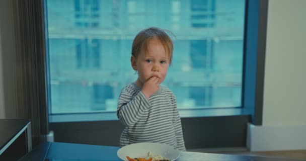Schattig jongetje eten lunch in de stad appartement — Stockvideo
