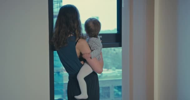 Μητέρα και νήπιο απολαμβάνουν τη θέα στο διαμέρισμα της πόλης — Αρχείο Βίντεο