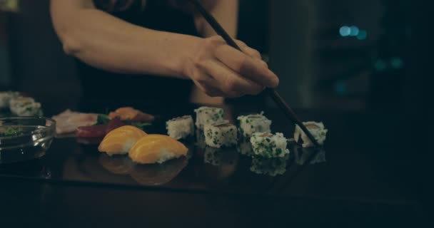 Panning lövés nő eszik sushin a városban éjjel — Stock videók