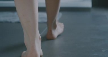 Genç bir bayanın duşa girerken ayaklarına yakın dur.