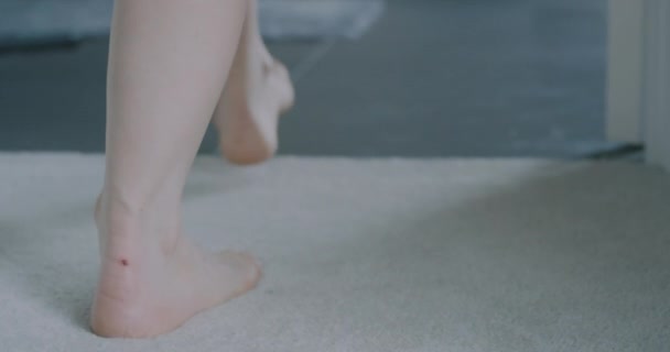 Gros plan sur les pieds de la jeune femme marchant vers la douche — Video