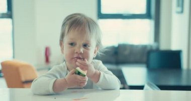 Küçük tatlı bir çocuk, şehirde bir dairede karpuz yiyor.