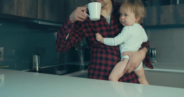 Ung Far Köket Och Håller Sin Son Och Dricker Kaffe — Stockvideo