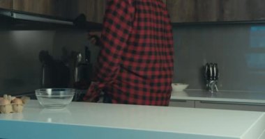 Komik bir hippi mutfakta elinde ağır çekimde bir spatulayla dans ediyor.
