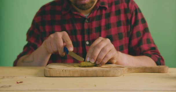 Jovem Está Cortando Pepino Contra Uma Tela Verde Câmera Lenta — Vídeo de Stock