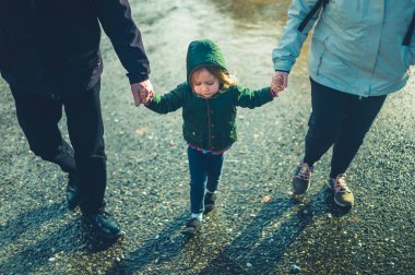 Büyükbaba ve torun kışın el ele yürüyorlar.