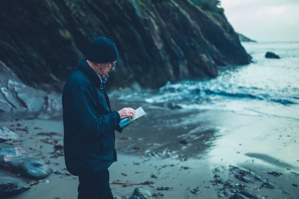 Dojrzały Mężczyzna Studiuje Zimą Mapę Plaży — Zdjęcie stockowe