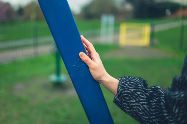 一位年轻女子的手正在摸公园里的游乐器材 — 图库照片