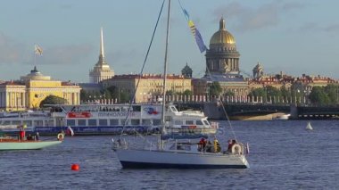 Sessizce dalgalar ve şehir arka plan üzerinde yakınındaki bir hareketli tekne sallanan demirlemiş teknelerin görünümü
